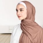 A woman wearing a draped ribbed jersey hijab. Modify.pk