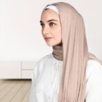 A woman wearing a draped ribbed jersey hijab. Modify.pk