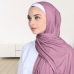 A woman wearing a draped ribbed jersey hijab. Modify.pk